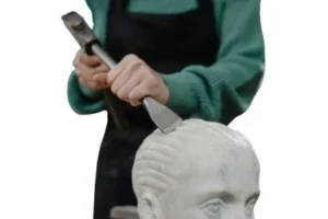 a lady using chisel and hammer